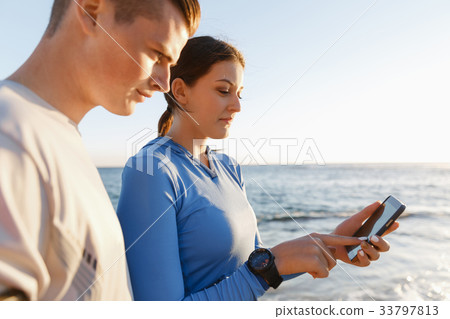 Young couple with smartphones outdoors 33797813