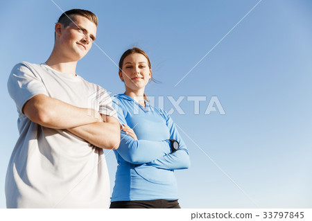 Young couple on beach training together Young couple on beach training together 33797845