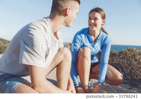 Couple of runners lace their shoes and prepare to jogging 33798241