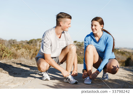 Couple of runners lace their shoes and prepare to jogging 33798242