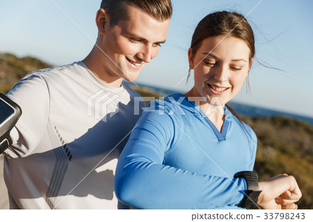 Runner woman with heart rate monitor running on beach Runner woman with heart rate monitor running on beach 33798243