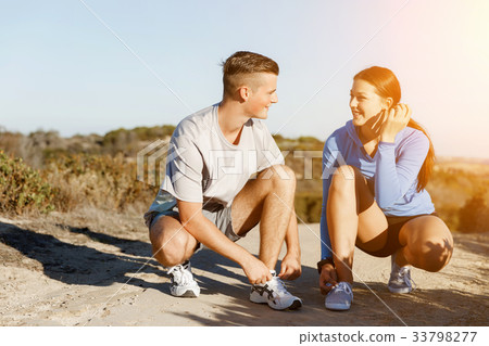 Couple of runners lace their shoes and prepare to jogging 33798277