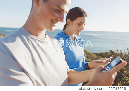 Young couple with smartphones outdoors 33798528
