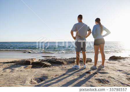 Young couple on beach training together Young couple on beach training together 33798557