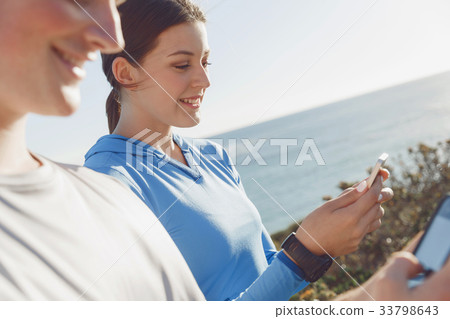 Young couple with smartphones outdoors Young couple with smartphones outdoors 33798643