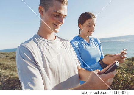 Young couple with smartphones outdoors Young couple with smartphones outdoors 33798791