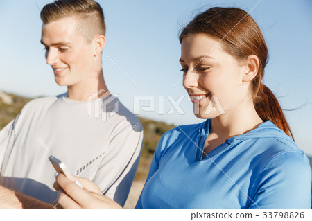 Young couple with smartphones outdoors 33798826