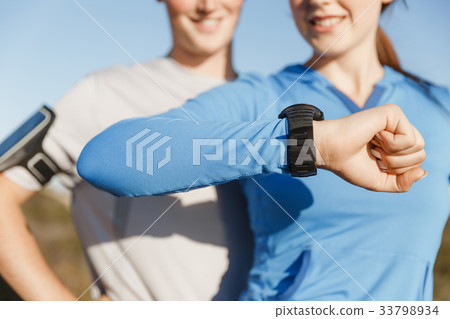 Runner woman with heart rate monitor running on beach Runner woman with heart rate monitor running on beach 33798934