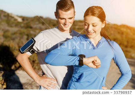 Runner woman with heart rate monitor running on beach Runner woman with heart rate monitor running on beach 33798937