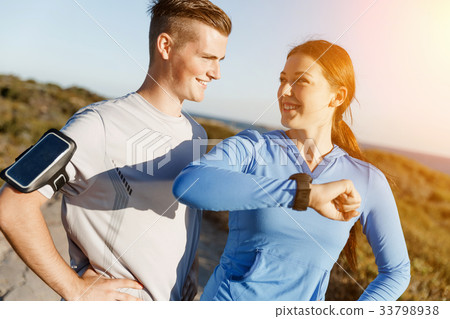 Runner woman with heart rate monitor running on beach Runner woman with heart rate monitor running on beach 33798938