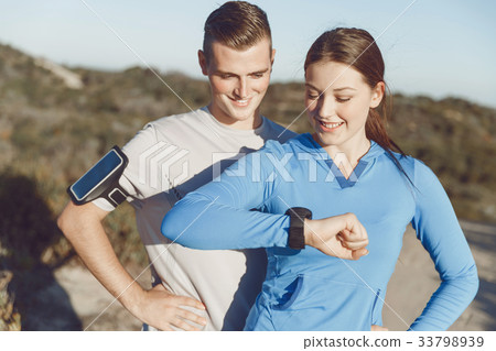 Runner woman with heart rate monitor running on beach Runner woman with heart rate monitor running on beach 33798939