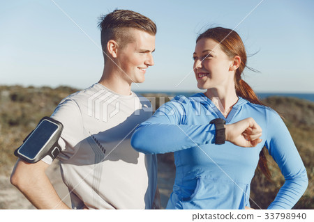 Runner woman with heart rate monitor running on beach Runner woman with heart rate monitor running on beach 33798940