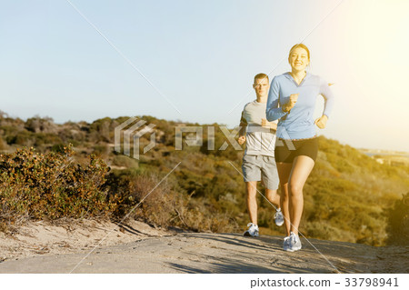 Sport runner jogging on beach working out with her partner Sport runner jogging on beach working out with her partner 33798941
