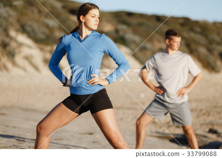 Young couple on beach training together 33799088