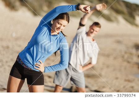 Young couple on beach training together 33799374