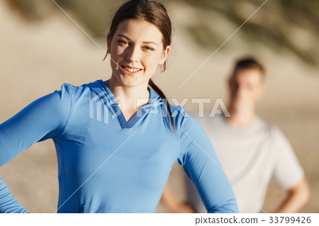 Young couple on beach training together Young couple on beach training together 33799426