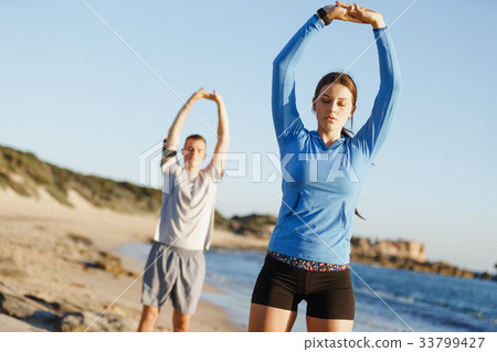 Young couple on beach training together 33799427