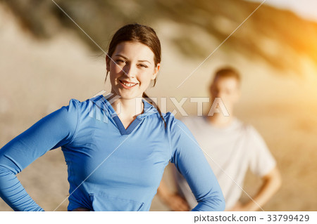 Young couple on beach training together Young couple on beach training together 33799429