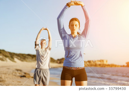 Young couple on beach training together 33799430