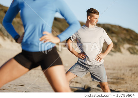 Young couple on beach training together Young couple on beach training together 33799604