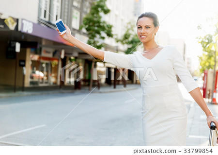 Business woman pulling suitcase bag walking in city 33799854