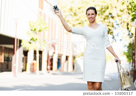 Business woman pulling suitcase bag walking in city Business woman pulling suitcase bag walking in city 33800317