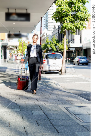 Business woman pulling suitcase bag walking in city 33800446