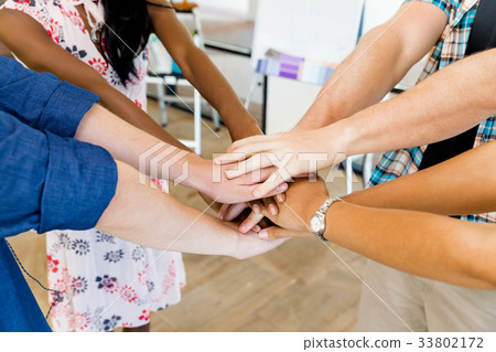 Top view of young people putting hands together Top view of young people putting hands together 33802172