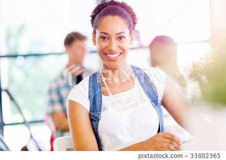 Portrait of smiling afro-american office worker sitting in offfice Portrait of smiling afro-american office worker sitting in offfice 33802365