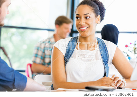 Portrait of smiling afro-american office worker sitting in offfice 33802401