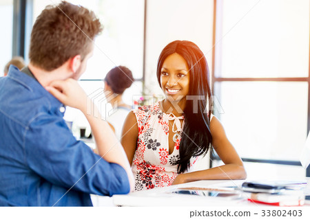 Portrait of smiling afro-american office worker sitting in offfice 33802403