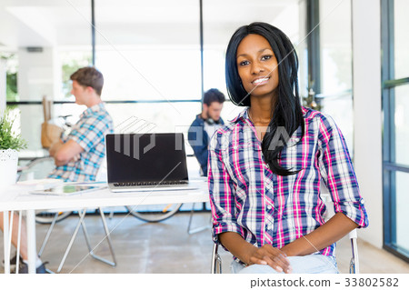 Portrait of smiling afro-american office worker in offfice with her colleagues Portrait of smiling afro-american office worker in offfice with her colleagues 33802582