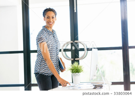 Portrait of smiling afro-american office worker standing in offfice 33803064