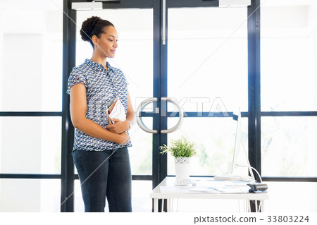 Portrait of smiling afro-american office worker standing in offfice Portrait of smiling afro-american office worker standing in offfice 33803224