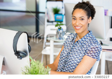 Portrait of smiling afro-american office worker sitting in offfice Portrait of smiling afro-american office worker sitting in offfice 33803227