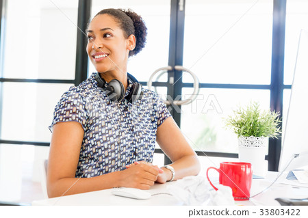 Portrait of smiling afro-american office worker sitting in offfice Portrait of smiling afro-american office worker sitting in offfice 33803422
