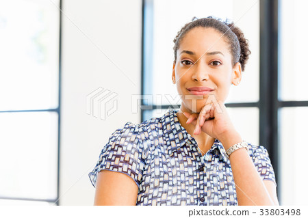 Portrait of smiling afro-american office worker sitting in offfice 33803498