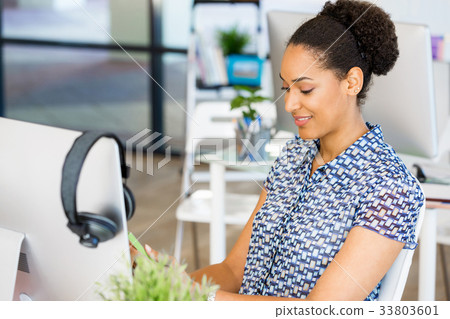 Portrait of smiling afro-american office worker sitting in offfice Portrait of smiling afro-american office worker sitting in offfice 33803601