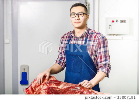 Worker with raw meat 33807191