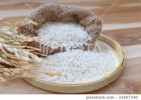 Paddy and white rice on wooden background. Paddy and white rice on wooden background. 33807340