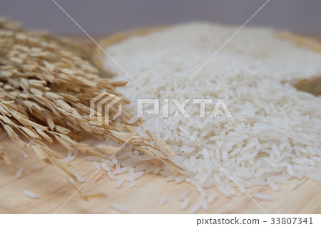 Paddy and white rice on wooden background. Paddy and white rice on wooden background. 33807341