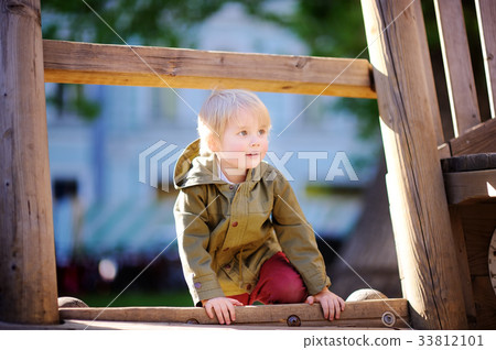 Happy little boy having fun on outdoor playground Happy little boy having fun on outdoor playground 33812101
