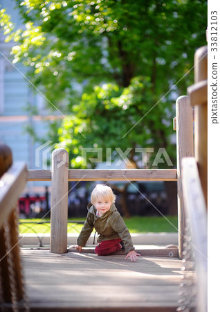 Happy little boy having fun on outdoor playground Happy little boy having fun on outdoor playground 33812103