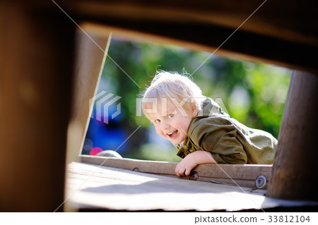 Happy little boy having fun on outdoor playground Happy little boy having fun on outdoor playground 33812104