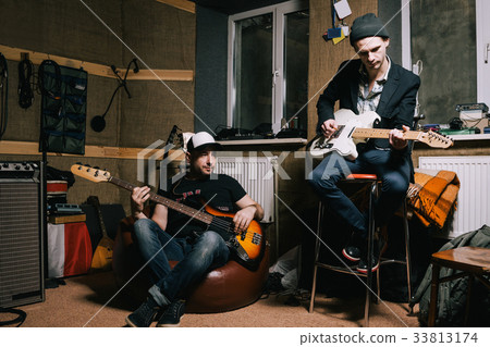 Band of adult guitarists rehearsing in studio 33813174