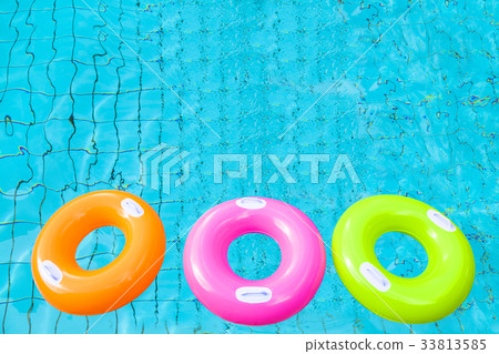three colorful swimming pool rings on the water 33813585