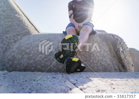 young man sitting on a concrete wall young man sitting on a concrete wall 33817357