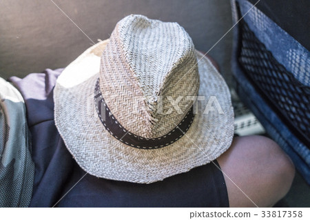 old straw hat, laying on a lap old straw hat, laying on a lap 33817358