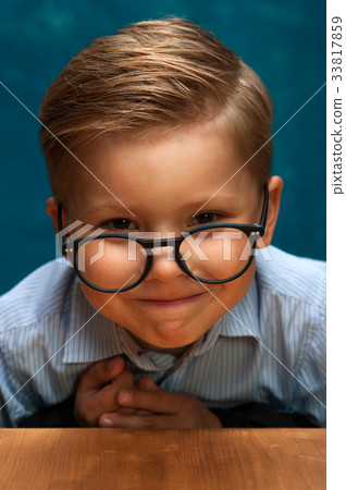Smiling businessman child sitting at the table 33817859