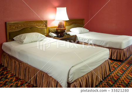 Double bed with table lamp in the bedroom 33821280